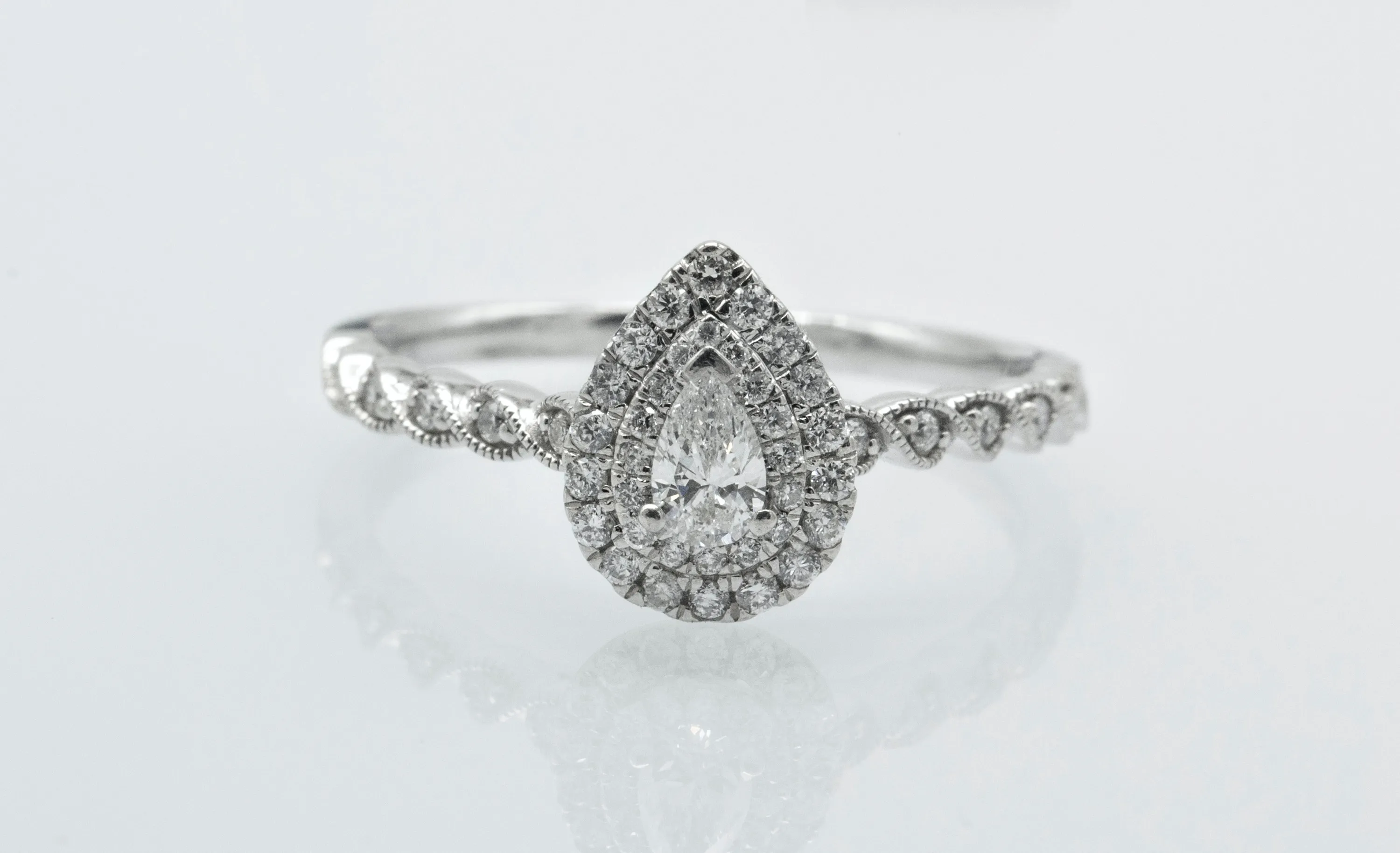 Weißgoldring mit tropfenförmigem Diamanten und Diamantbesatz