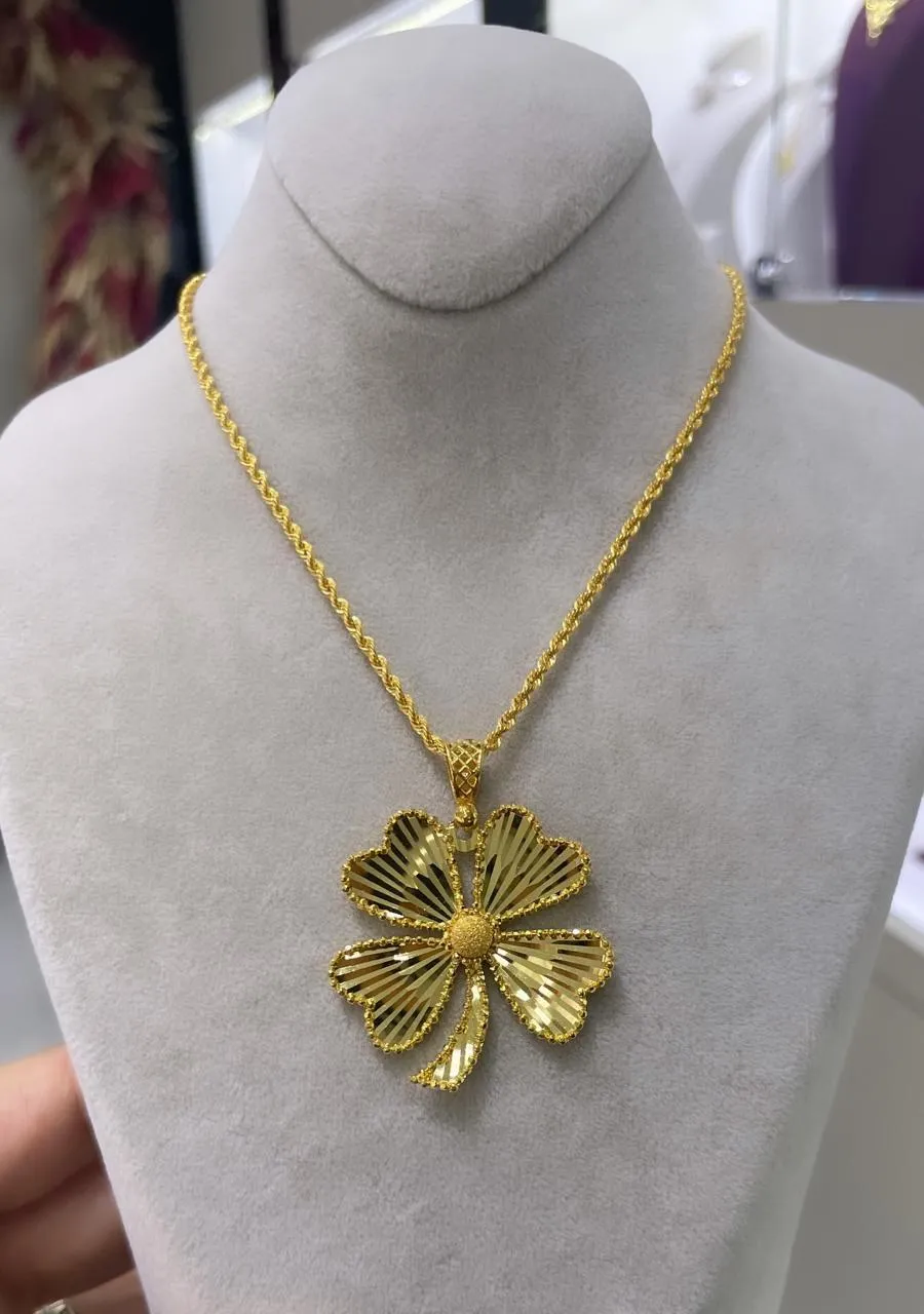 Goldkette mit großem Kleeblatt-Anhänger aus 22 Karat Gold auf einer Büste