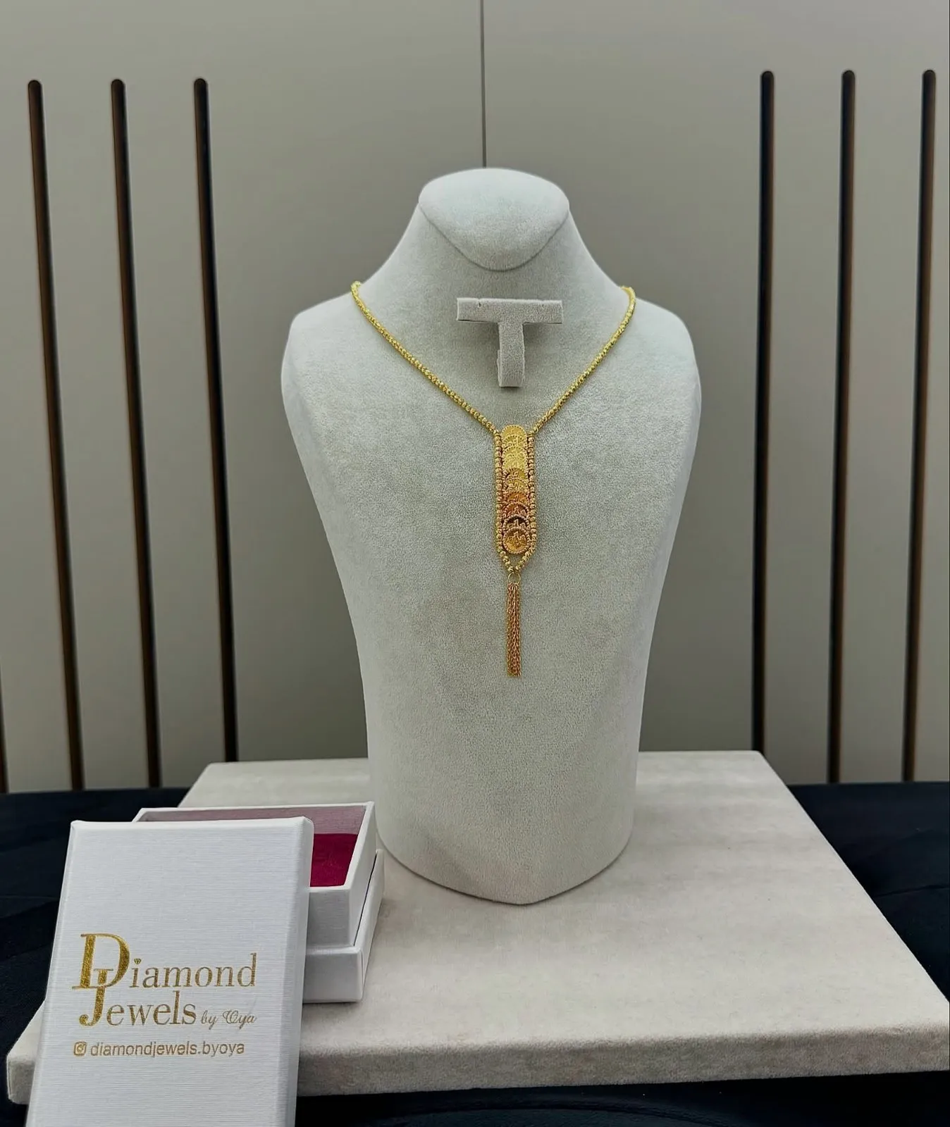 Lange Goldkette mit Anhänger auf einer hellen Büste